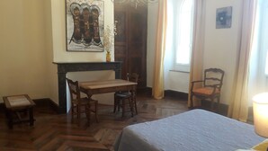 A room with a bed, a wooden table, two chairs, a painting on the wall, and a window with curtains. - Magnificent and large 18th century house, in a mountain village (Luz-Saint-Sauveur)