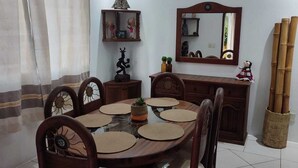 A dining area with a round table, chairs, a mirror, and decorative items. - Nice condominium with lots of amenities. Huatulco (Crucecita)