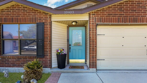 A two-story brick house with a blue front door, a garage door, and a mailbox. - Spacious Home with Pool Sleeps 10  Near Lackland BMT Graduation Family Friendly (San Antonio)