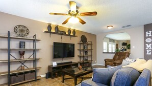 A living room with a television, a ceiling fan, a sofa, and a coffee table. - Spacious Home with Pool Sleeps 10  Near Lackland BMT Graduation Family Friendly (San Antonio)