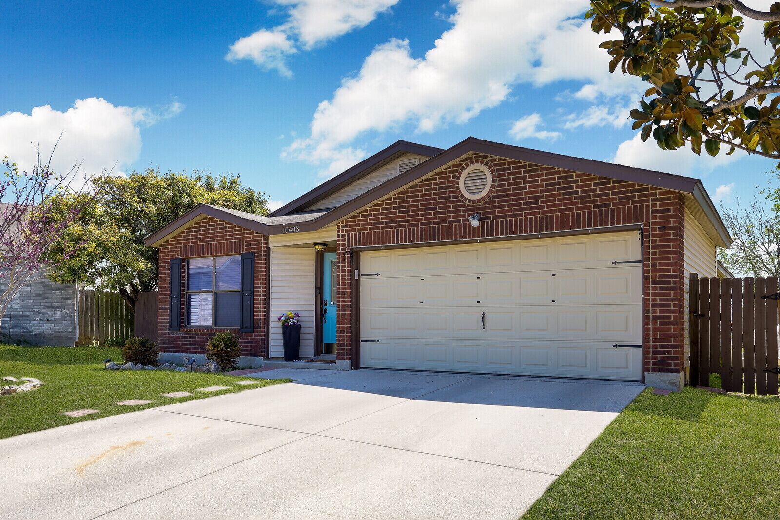 A single-story brick house with a garage, a front door, and a small porch area.