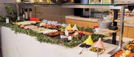 A buffet with various food items and a coffee station.