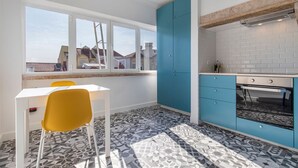Een moderne keuken met blauwe kastjes, een wit aanrechtblad en een vloer met een patroon.