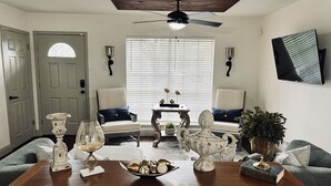 A living room with two armchairs, a coffee table, a fireplace, and a ceiling fan.