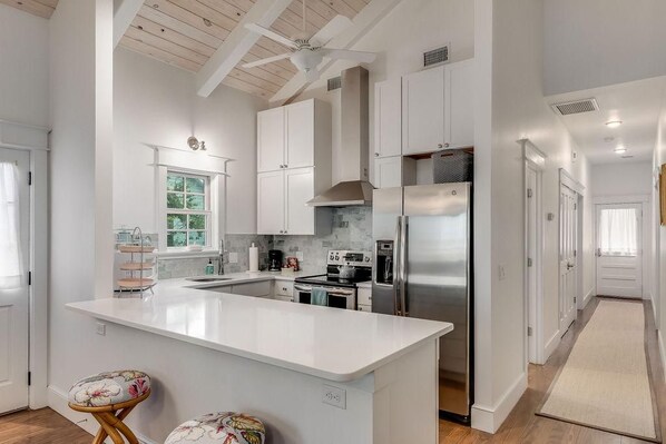 A modern kitchen with white cabinetry, a central island, and stainless steel appliances.