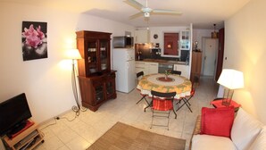 A compact living space with a dining area, kitchenette, and a television in the corner. - Apartment (Saint-Mandrier-sur-Mer)