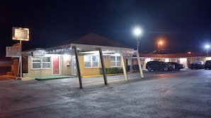 A small building with a sign indicating free high-speed wireless internet, a payphone, and a microwave. - Western Motel (Abilene)