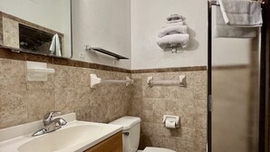 A bathroom with a sink, toilet, and shower. - Western Motel (Abilene)
