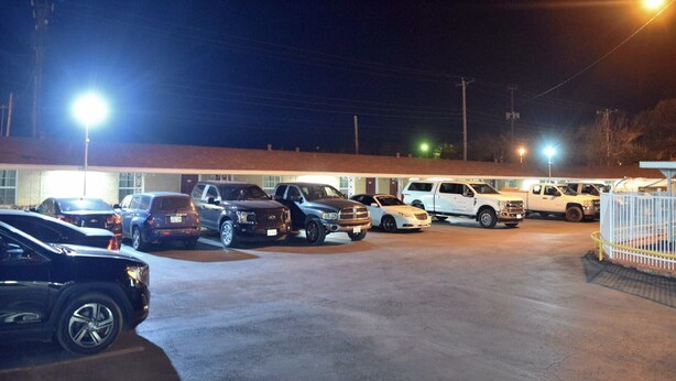 A parking lot with several cars parked in front of a building with a brick facade and a flat roof. - Western Motel (Abilene)