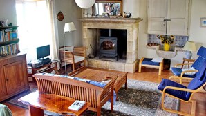 Een gezellige woonkamer met een open haard, houten meubels en een televisie.