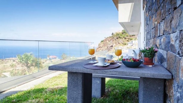 Ein Tisch mit Frühstücksangeboten und Blick auf den Ozean.