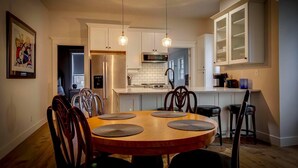 A modern kitchen with white cabinets, a central island, and pendant lighting. - Excellent 3BR/2BA PRIME Location! (Louisville)