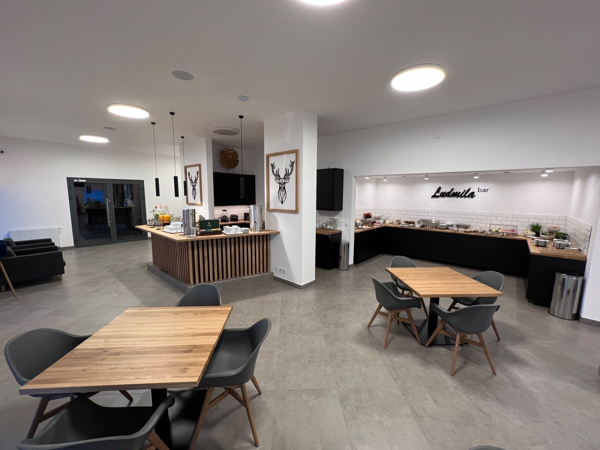 Zona de bar moderna con mostrador, asientos y una televisión.