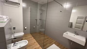 Une salle de bain moderne avec une douche à parois de verre, une baignoire sur pieds, un lavabo et des toilettes.
