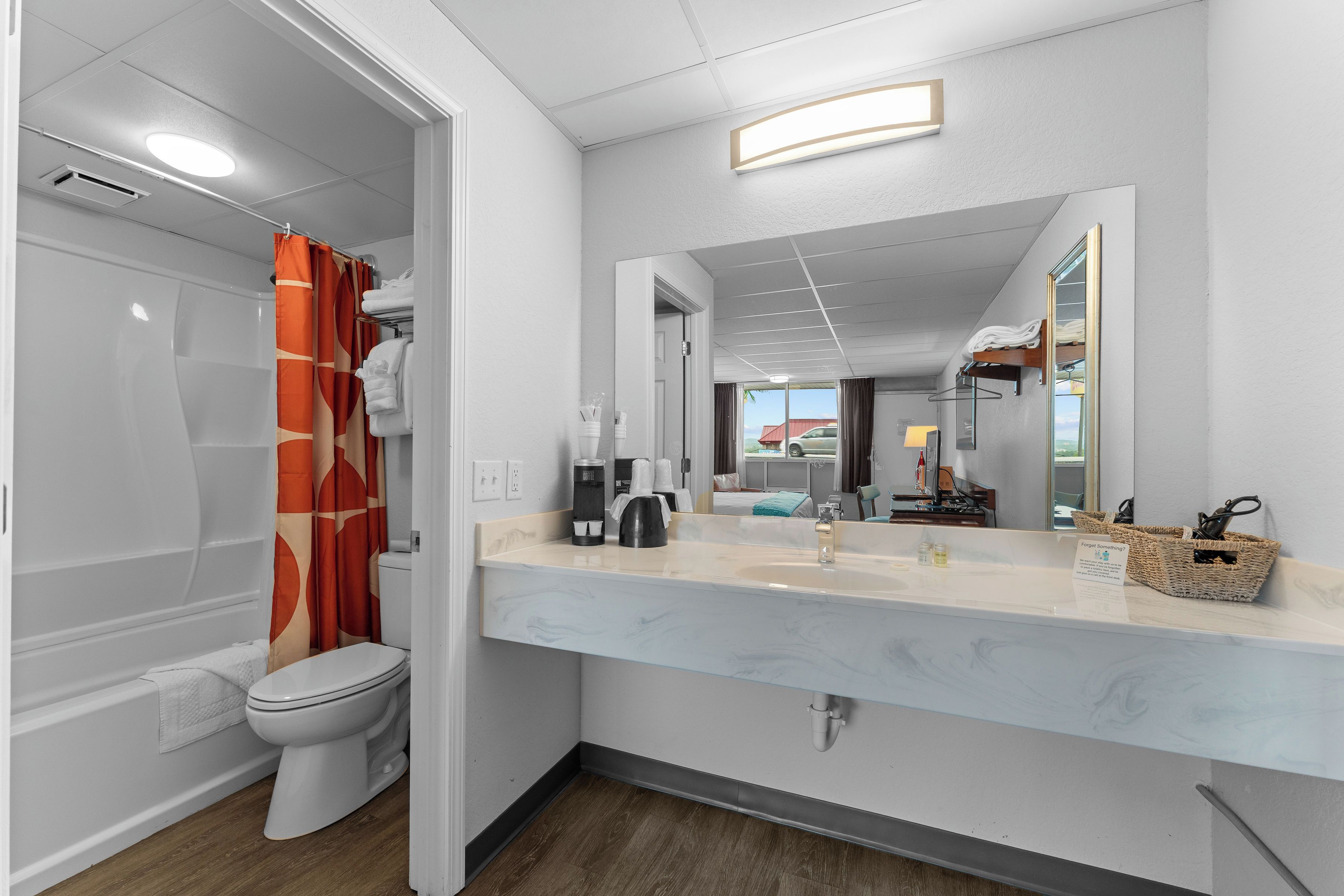 Un baño moderno con ducha, inodoro y tocador con espejo.
