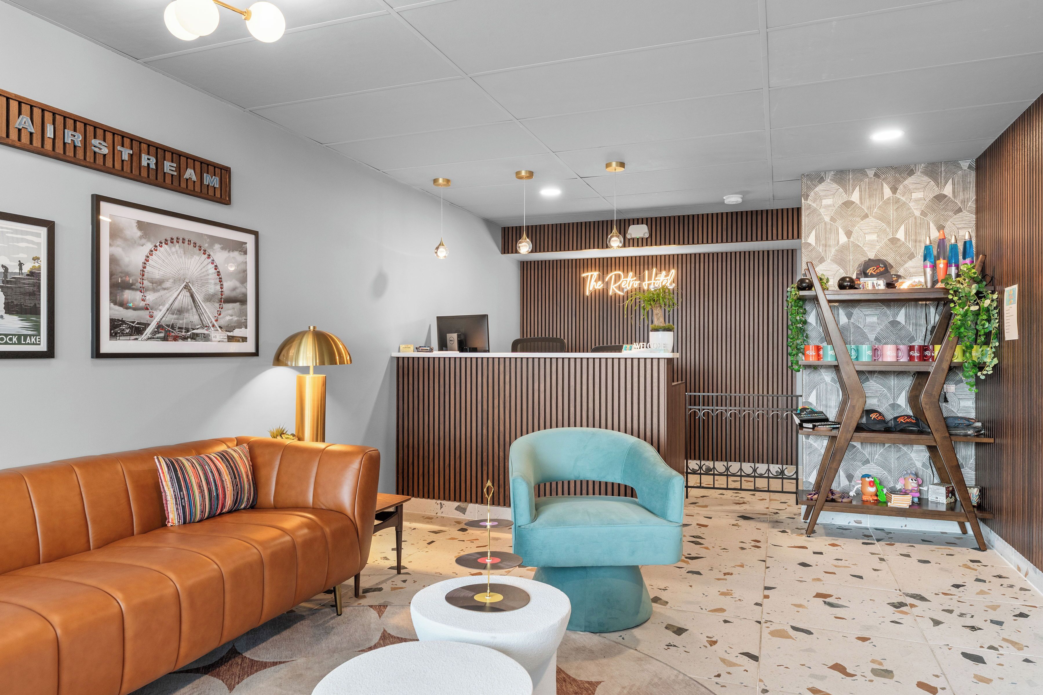 Eine moderne Hotelhalle mit einer Rezeption, einer Couch, einem Sessel und einer Wandverkleidung.