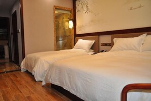 A hotel room with two beds, a wooden floor, a large mirror, and a wall with a painting. - Chunqiu Shuyuan Hotel (Feicheng)