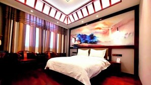 A hotel room with a large bed, a painting on the wall, and a view of the cityscape. - Chunqiu Shuyuan Hotel (Feicheng)