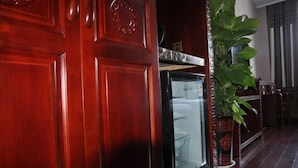 A wooden door with a glass panel and a potted plant beside it. - Chunqiu Shuyuan Hotel (Feicheng)