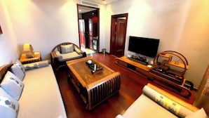 Ein Wohnzimmer mit einer Couch, einem Couchtisch, einem Fernseher und einer Holz-Unterhaltungseinrichtung.