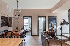 A modern interior with a dining area, a leather sofa, and a lamp.