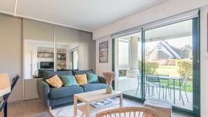 Ein modernes Wohnzimmer mit Sofa, Couchtisch und Korbsessel.