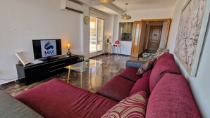 A modern living room with a sofa set, a TV, and a glass coffee table. - Sea Breeze Apartment | Spacious Terrace (Fuengirola)