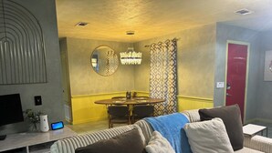 Una sala de estar acogedora con un sofá, una mesa de comedor y un televisor.