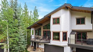 A two-story house with a covered porch, large windows, and a garage. - Spacious East Vail Getaway by Vail Butler (Vail)