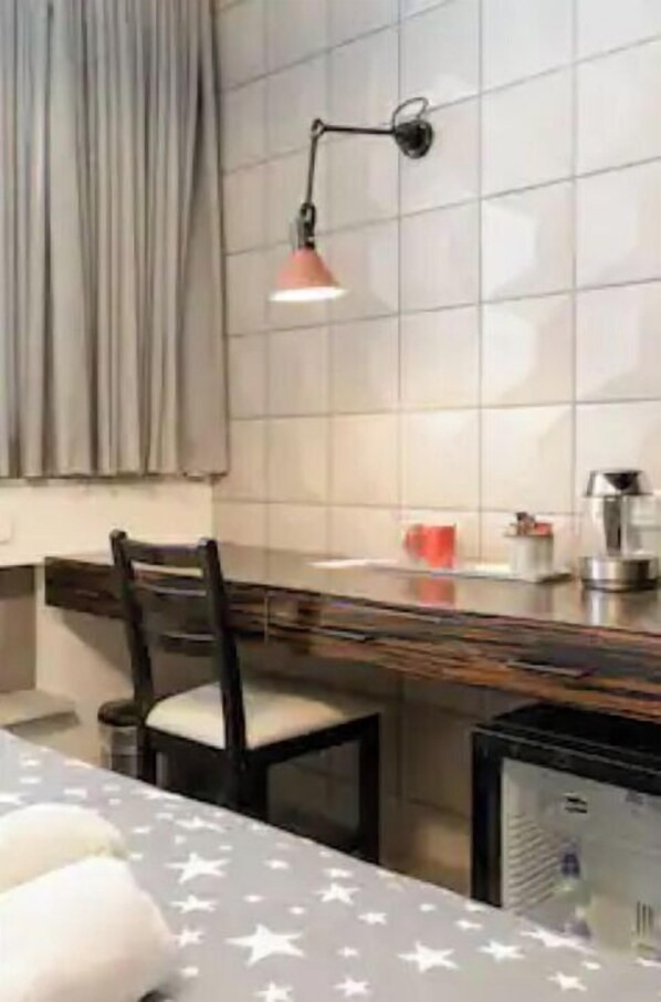 Functional kitchen with a sleek countertop, chair, and tiled backsplash, offering a view of the outside.