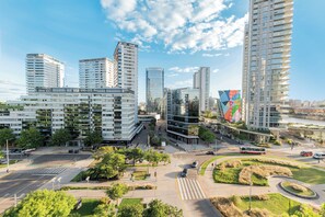 Uma área urbana moderna com edifícios altos, um rotatório central e áreas verdes.