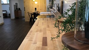 Une cuisine moderne avec un plan de travail en bois, une cuisinière encastrée et des luminaires suspendus.