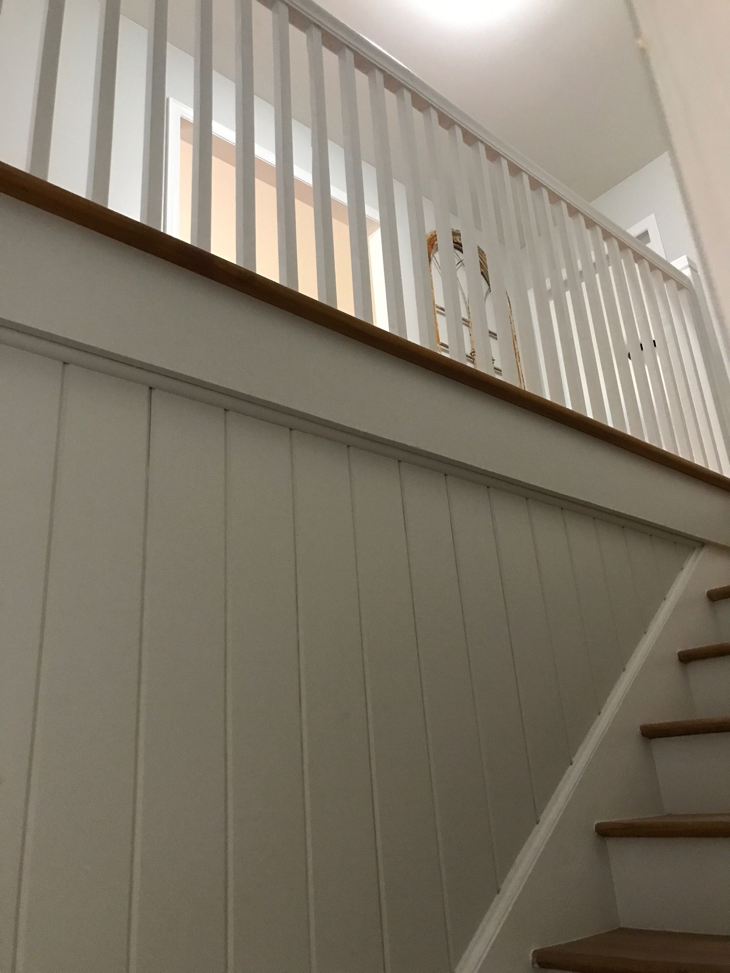A staircase with white railings and wooden steps.