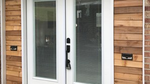 Une porte à deux battants avec un panneau en verre, une poignée en métal et un trou de serrure.