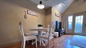 A dining area with a table and chairs, a potted plant, and a sign that reads "let's eat".