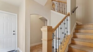 Eine Treppe mit Holzbalken und schwarzen Geländern, die zu einer oberen Etage führt.