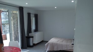 A modern bedroom with a bed, a small desk, and a table with chairs. - 30 m2 furnished apartment near shops and metro (Sotteville-lès-Rouen)