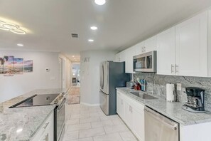 A modern kitchen with white cabinets, a stainless steel refrigerator, and a built-in oven. - *Upscale 2/2 condo with pool 6 mins from IMG (Bradenton)