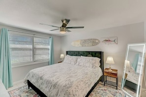 A bedroom with a bed, a ceiling fan, a window with blinds, a bedside table with a lamp, and a wall-mounted fish painting. - *Upscale 2/2 condo with pool 6 mins from IMG (Bradenton)
