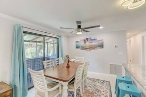 A dining area with a table, chairs, a ceiling fan, and a view through a window. - *Upscale 2/2 condo with pool 6 mins from IMG (Bradenton)