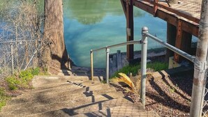 Un puente de madera sobre un estanque tranquilo, con escalones que bajan hacia el agua.