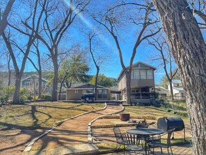 Ein Garten mit Grillplatz, Terrassentisch und Grill.