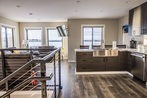 Een moderne keuken met donker houten kastjes, een roestvrijstalen spoelbak en uitzicht op het water.