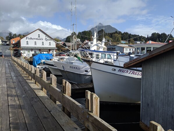 A dock with boats, a wooden pier, and a building labeled 'Fisherman's Quay'. - Fishermans Quay North Bunkhouse (Sitka)