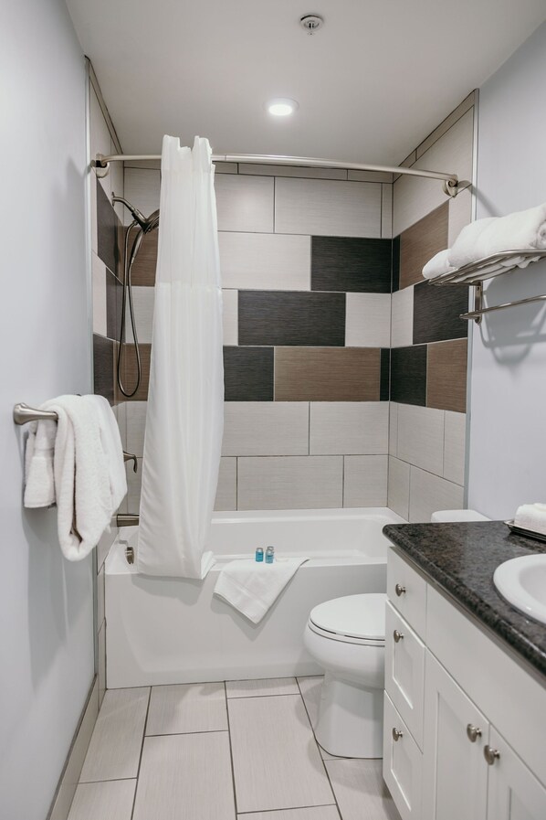 A modern bathroom with a shower, toilet, and vanity.