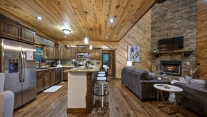Una cocina amplia con armarios de madera, un refrigerador y una chimenea de piedra.