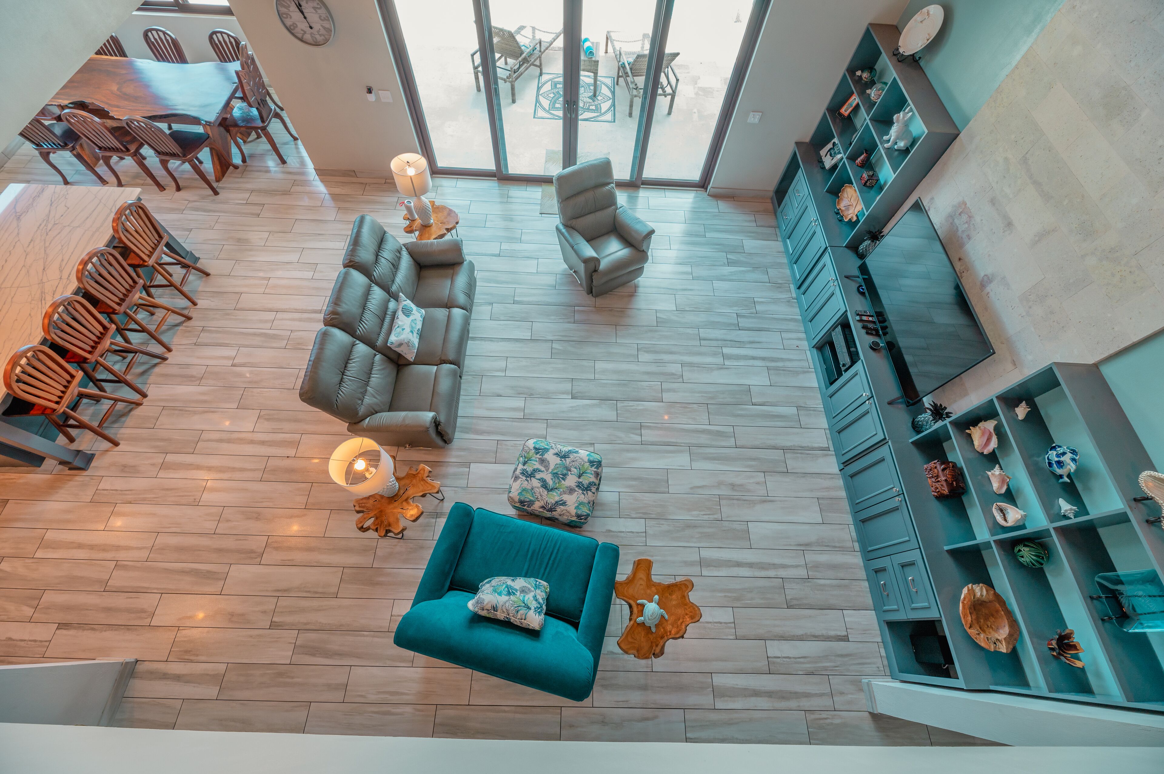 A spacious living area with a large dining table, comfortable seating, and a view through large windows.