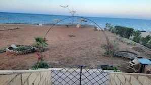 A beach with a staircase leading to a covered area, a sandy beach, and a view of the sea. - Beautiful villa with private beach on the Red sea (Бур-Сафага)