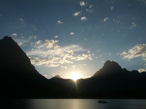 A boat on calm water with mountains in the background and the sun setting or rising. - Ol239 Meadow Lake Country Escape (Columbia Falls)