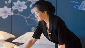 A room with a bed, a wall with a floral mural, and a pillow. - Wen Gong Hotel (Youxi)